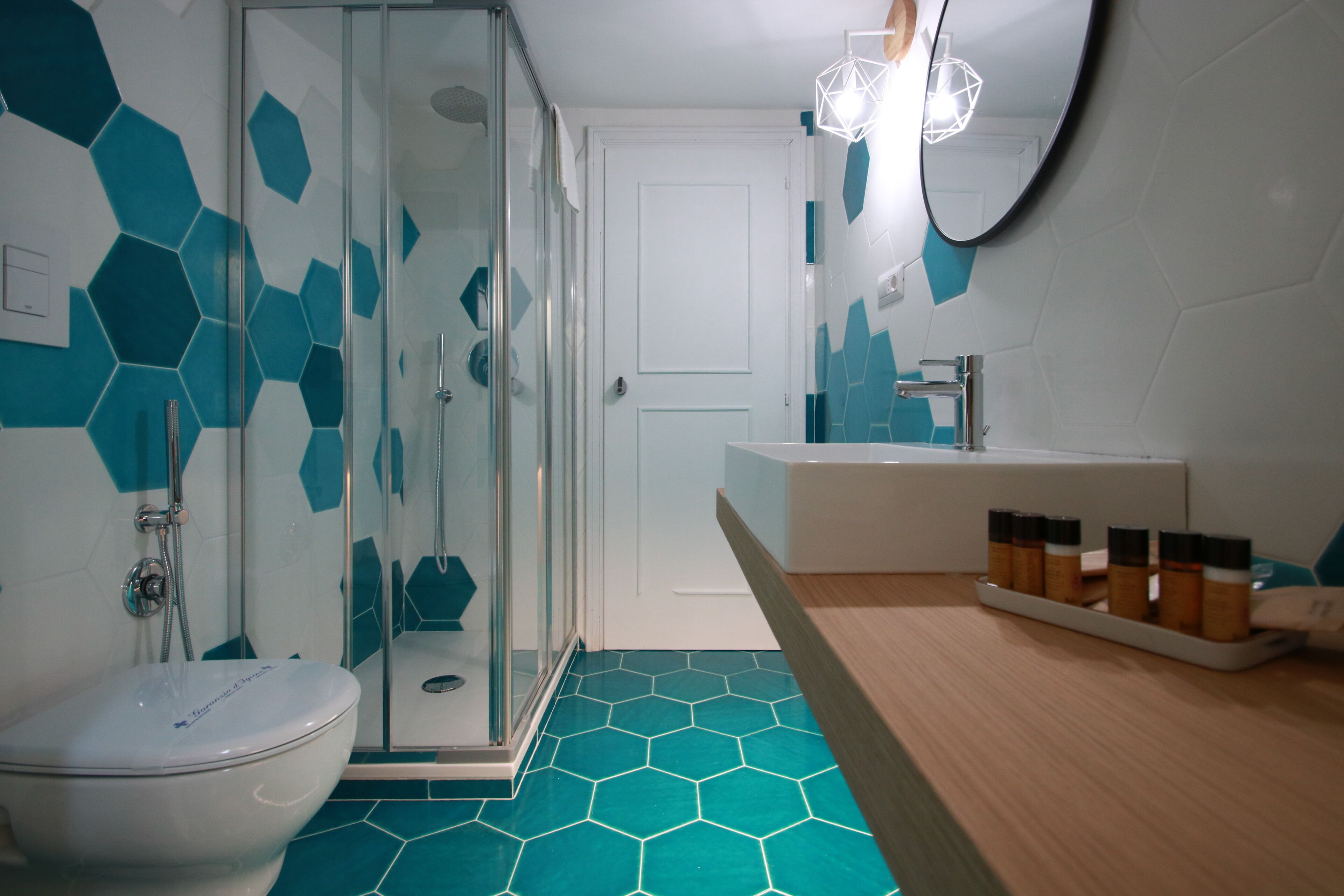 A bathroom with a glass-enclosed shower, a white toilet, and a sink with a countertop.