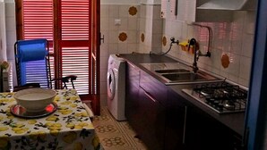 A compact kitchen with a washing machine, a sink, and a stove.