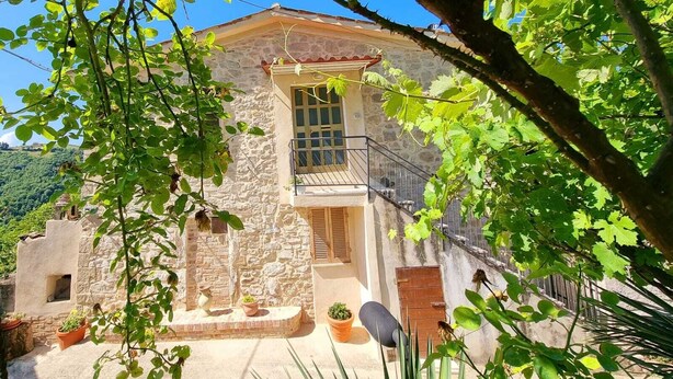 A stone building with a balcony, surrounded by greenery and a clear sky. - Vacation House The Laurels (Venarotta)