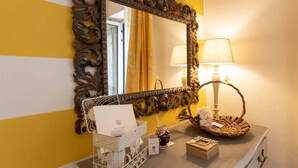 A vanity with a mirror, a lamp, and a basket on a dresser. - THE HOME OF JASMINE AND MEDLAR, TO MAKE YOU FEEL AT HOME. (Firenze)