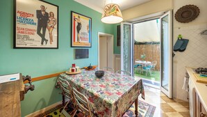 A dining area with a table set for two, a hanging lamp, and a poster on the wall. - THE HOME OF JASMINE AND MEDLAR, TO MAKE YOU FEEL AT HOME. (Firenze)