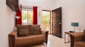 Una sala de estar con sofá, lámpara y puerta.