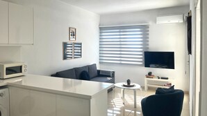 Ein moderner Wohnraum mit Küche, Essbereich und Sitzgelegenheit.