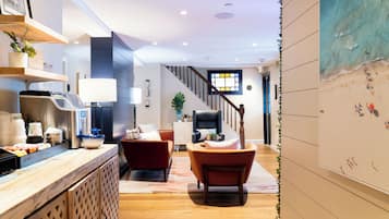 A modern kitchen with a wooden countertop, a red sofa, and a staircase leading to another level.