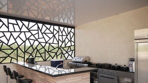 Een moderne keuken met een centraal eiland, barkrukken, een fornuis, oven en een koelkast.