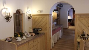 A wooden interior with a kitchen area, a dining table, and a fireplace. - Luxury Apartment Schoenbichl (Sankt Johann in Tirol)