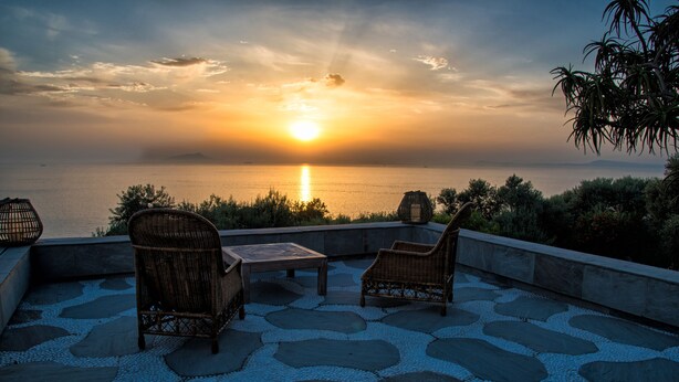 A terrace with wicker furniture and a view of the sunset over the sea. - Villa Rufola (Sorrento)