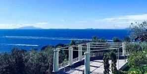 Vista al mar con una pérgola blanca que da sobre el océano.