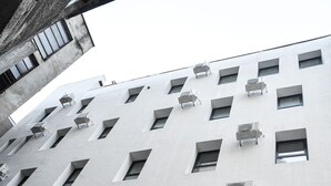 En bygning med flere klimaanlæg monteret på facaden.