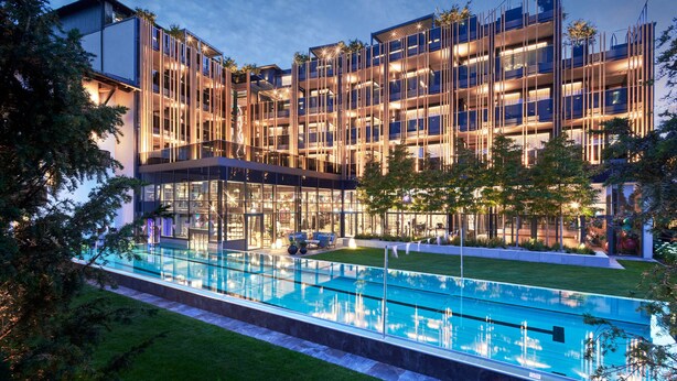 A modern hotel with a glass pool and outdoor seating area. - Wellness- & Sporthotel Jagdhof (Roehrnbach)