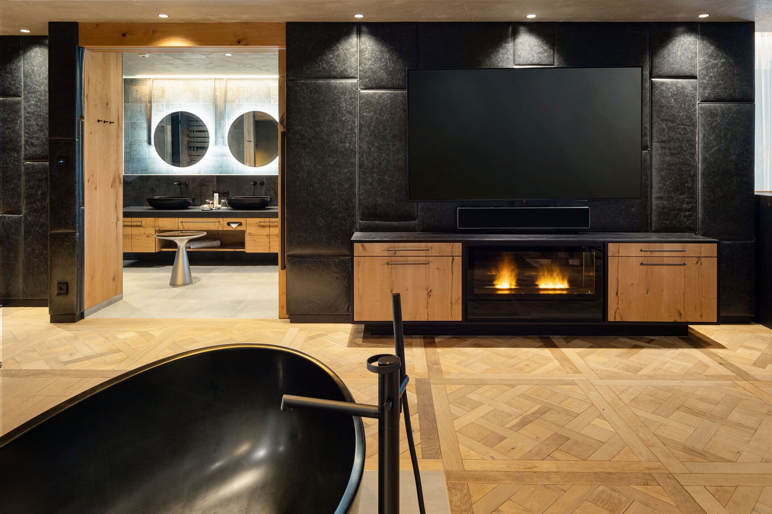 Una sala de estar moderna con chimenea, armarios de madera y un televisor de pantalla plana grande.