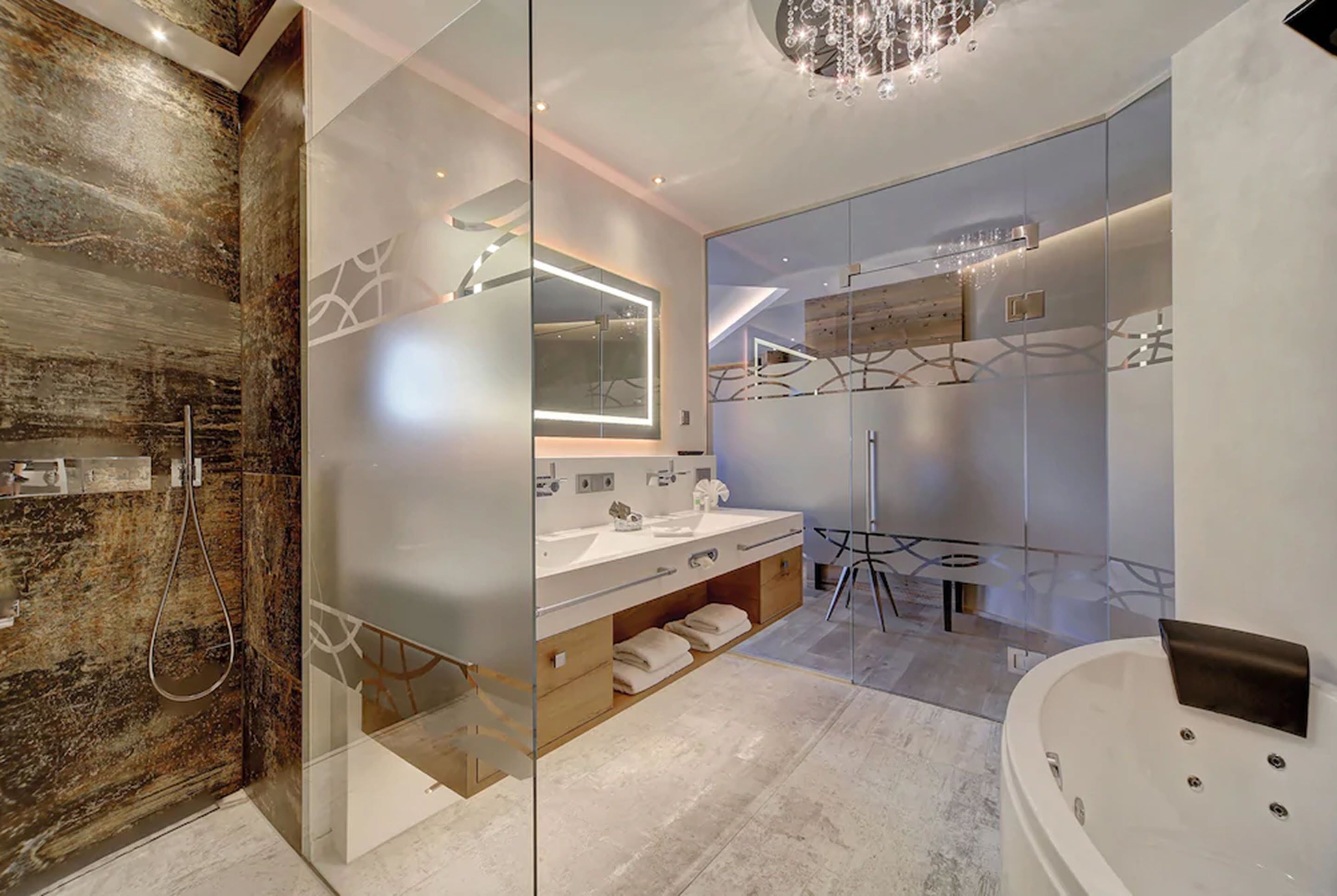 Een moderne badkamer met een douchecabine van glas, een vrijstaand bad en een wastafel met een grote spiegel.
