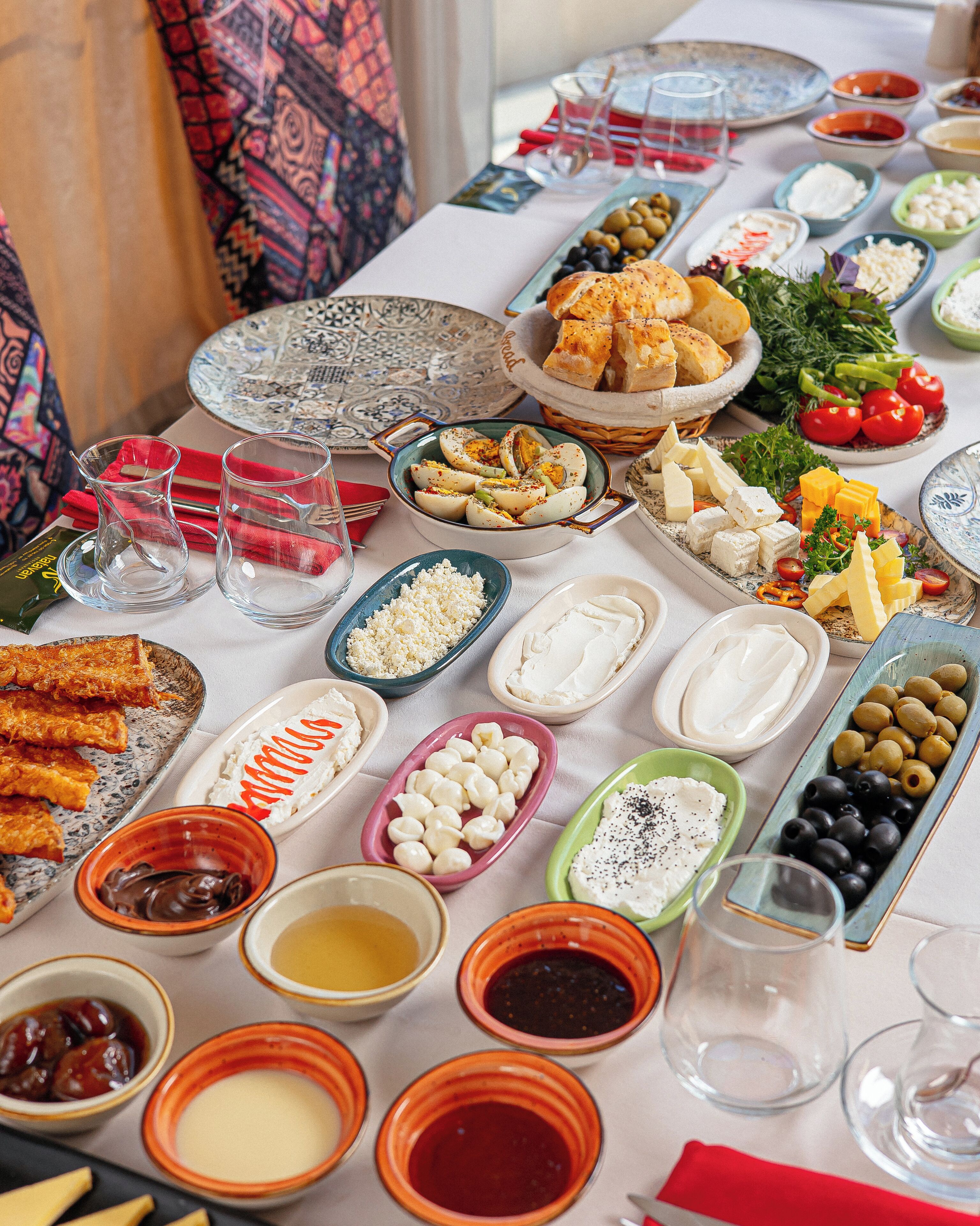 A table with various food items and drinks, including olives, cheese, and bread.