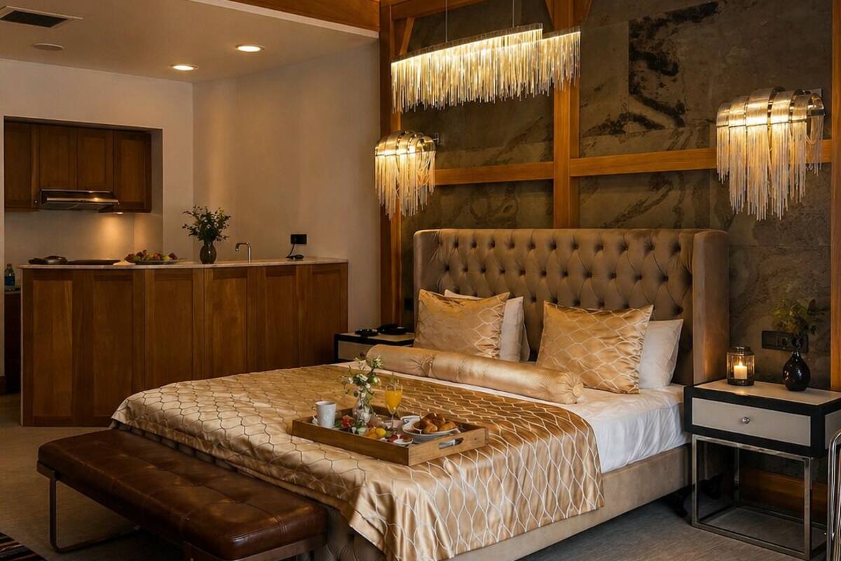 Quarto moderno com cama grande, escrivaninha de madeira e área de refeições.