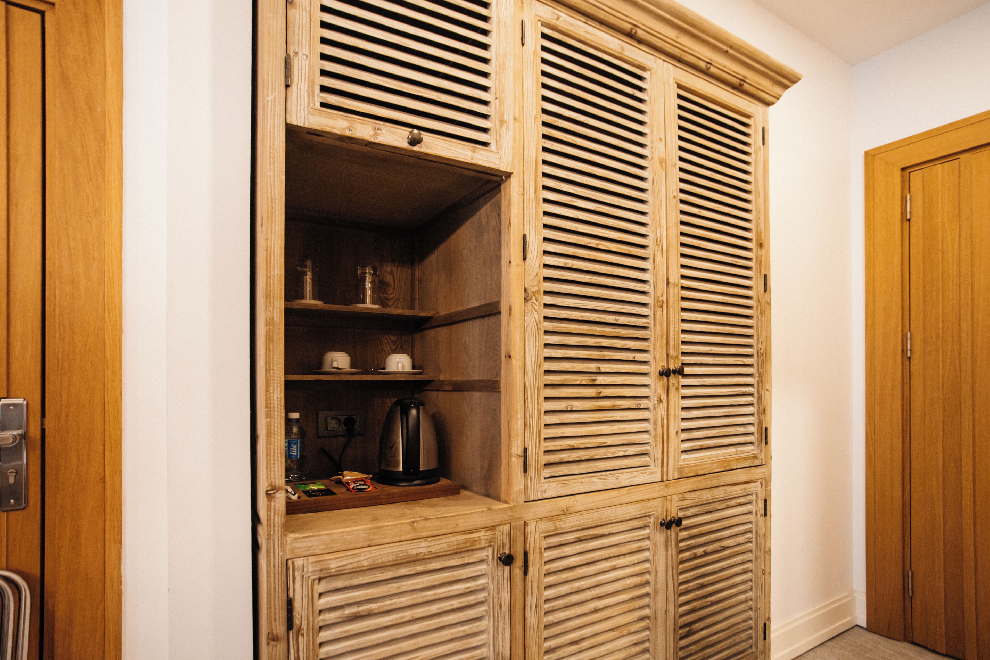 Een houten garderobe met verschillende vakken en een inbouwkast.