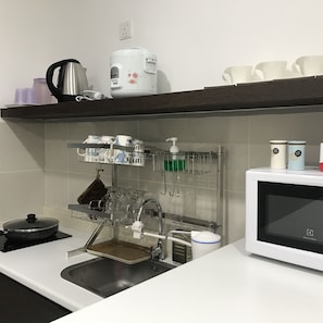 Kitchen equipped with a sink, microwave, kettle, and rice cooker.