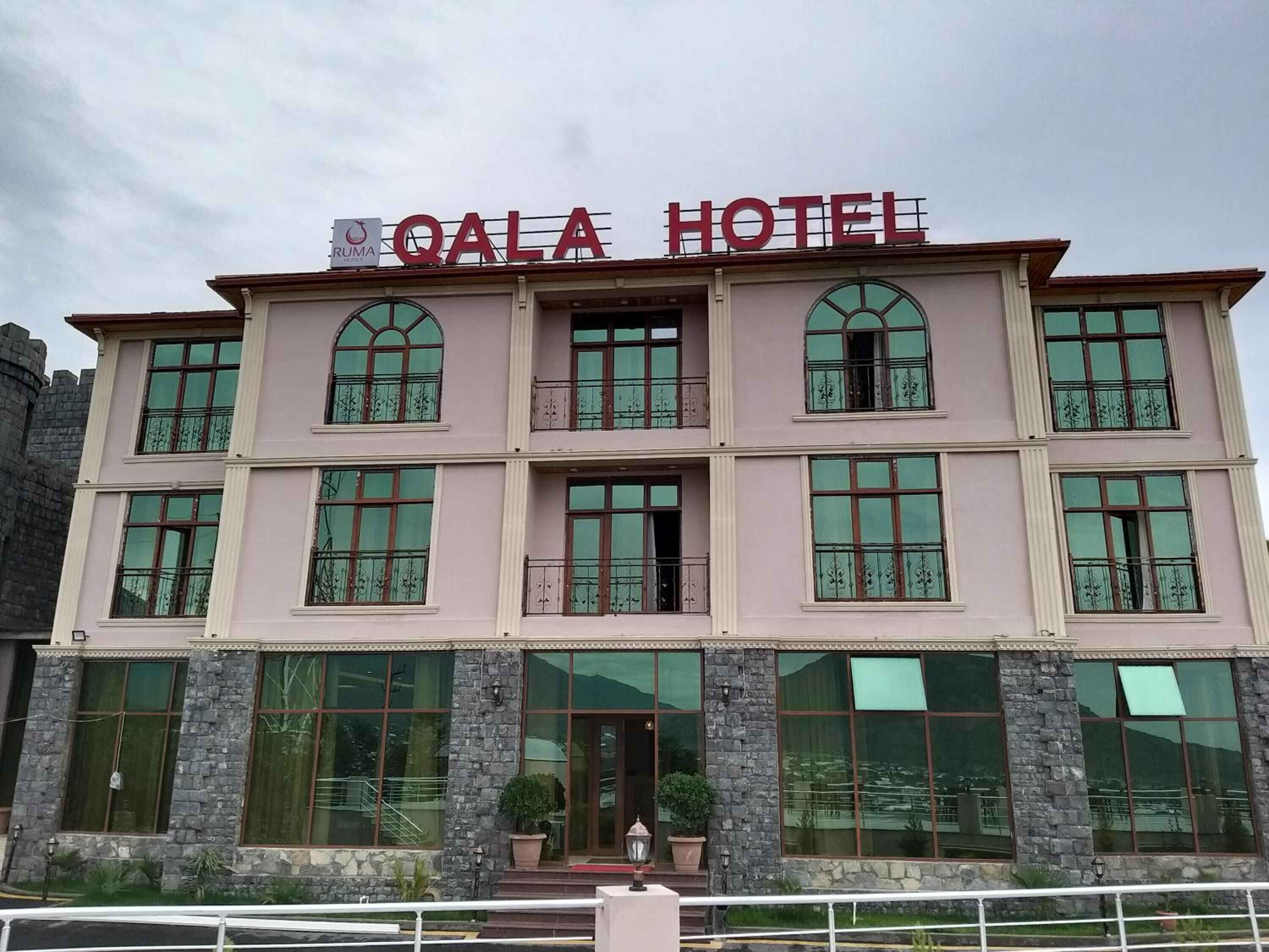 A multi-story building with the sign "QALA HOTEL" at the top.