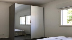 Ein Schlafzimmer mit Bett, Kleiderschrank und Fenster.