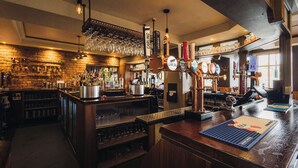 A bar area with a tap, glasses, and a menu board. - Griffin Inn (St Helens)