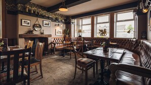 A traditional inn with a wooden interior, leather seating, and large windows. - Griffin Inn (St Helens)