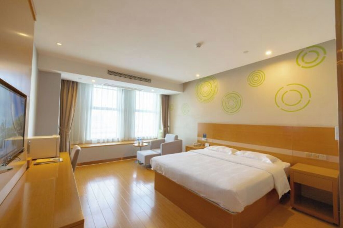 Une chambre d’hôtel moderne avec un grand lit, un bureau et un coin salon.