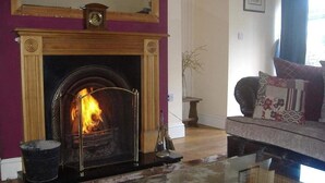 Una sala de estar con chimenea, un sofá y una mesa de centro de vidrio.