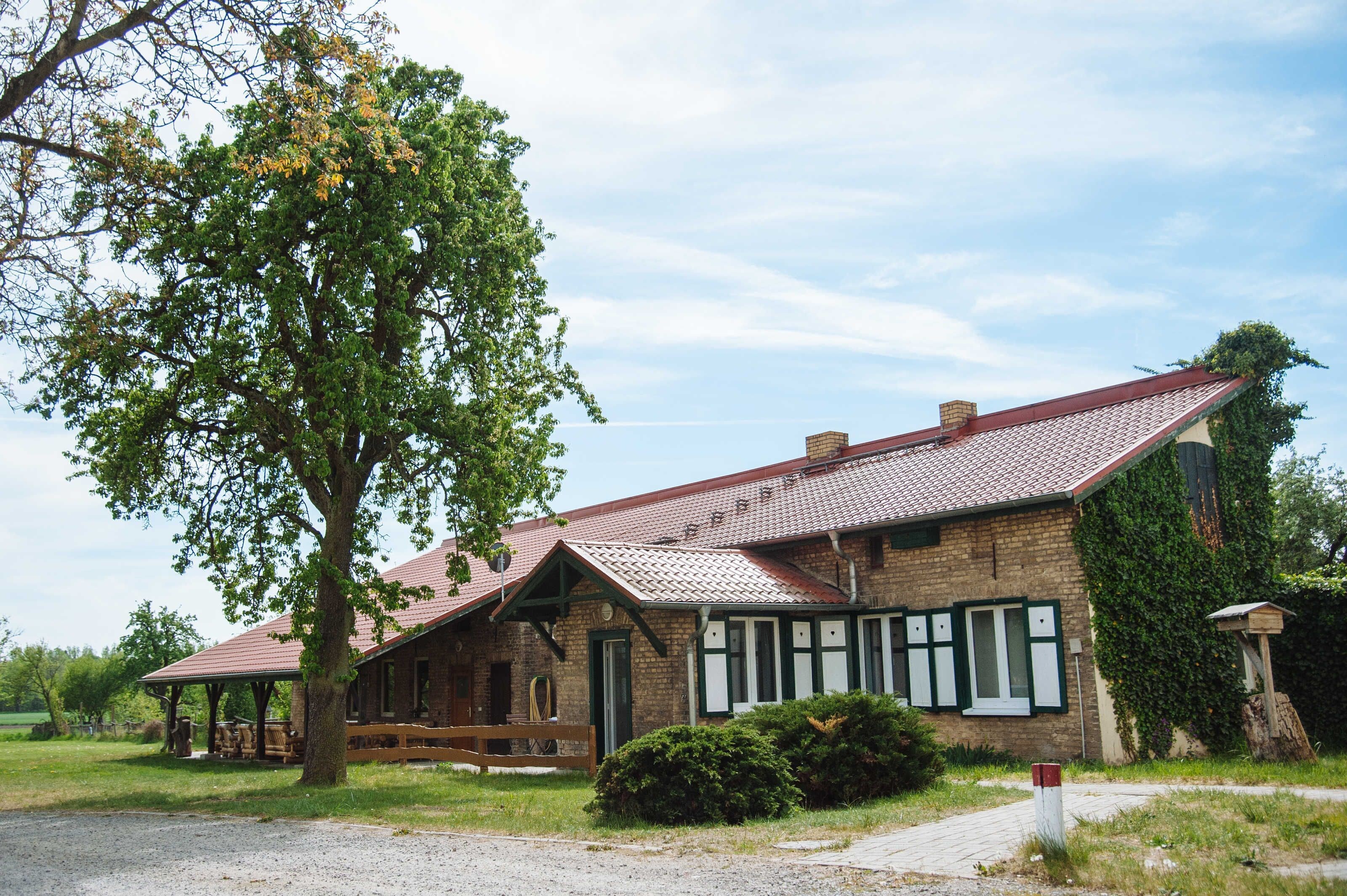 Un bâtiment de style rustique, doté d’un toit en pente, d’un porche abrité et d’une façade en briques.