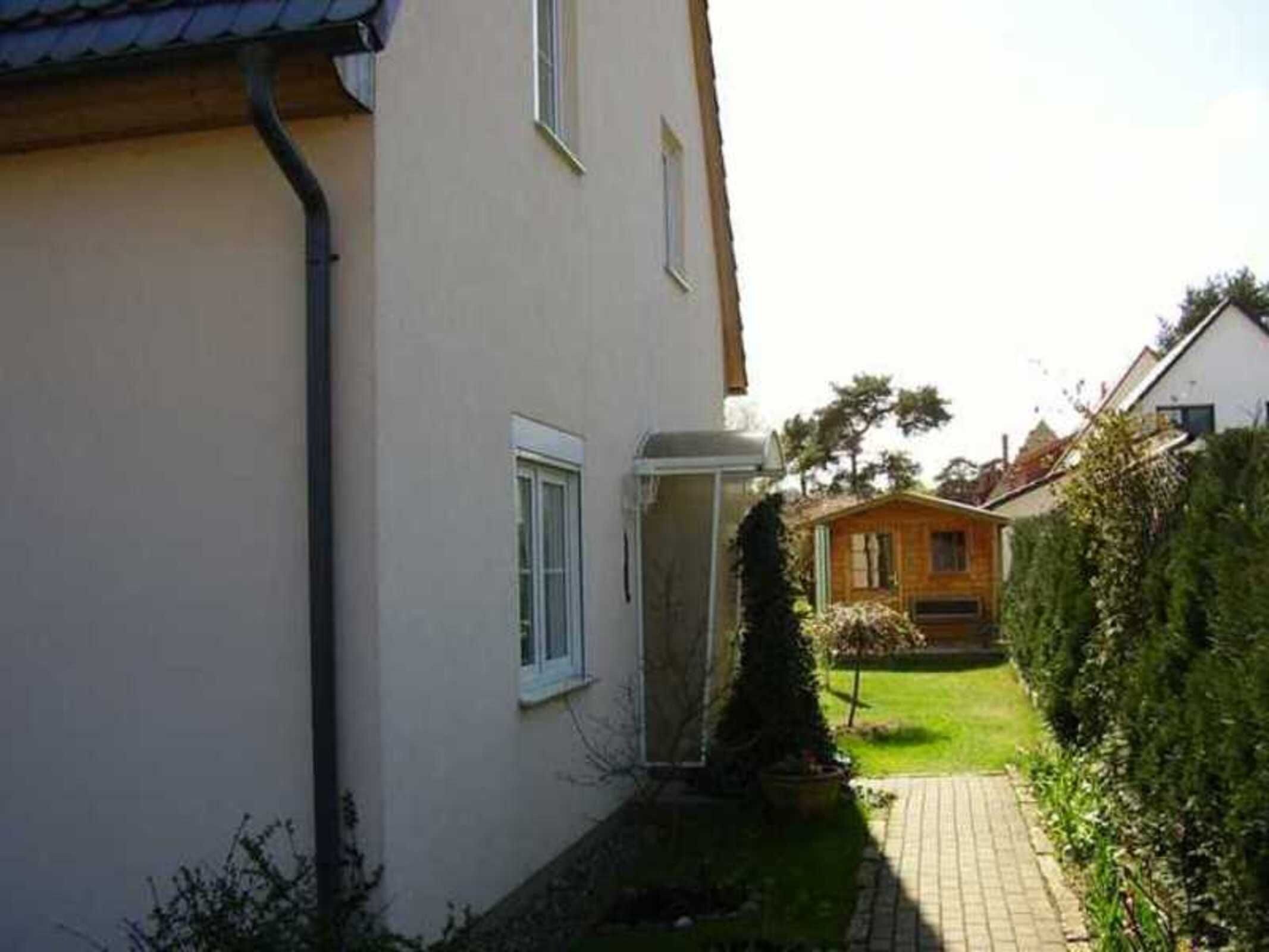 A building with a paved pathway leading to a wooden structure.