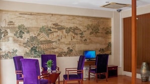 A room with a traditional Chinese mural on the wall, wooden flooring, and purple upholstered chairs. - GreenTree Alliance Suzhou Sports Center Xihuan Rd Hotel (Suzhou)