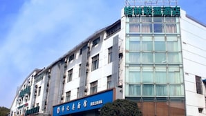 A hotel with a modern facade, multiple floors, and a prominent signage indicating it is a hotel. - GreenTree Alliance Suzhou Sports Center Xihuan Rd Hotel (Suzhou)