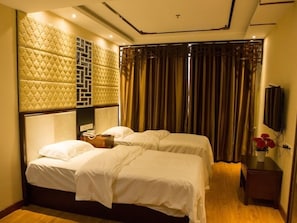 A hotel room with two beds, a large padded headboard, a television, and a wooden nightstand. - GreenTree Inn Zaozhuang Shanting Jinke International Business Hotel (Zaozhuang)