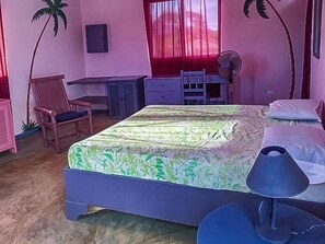 Une chambre à coucher avec un lit, un bureau, une chaise et un ventilateur.
