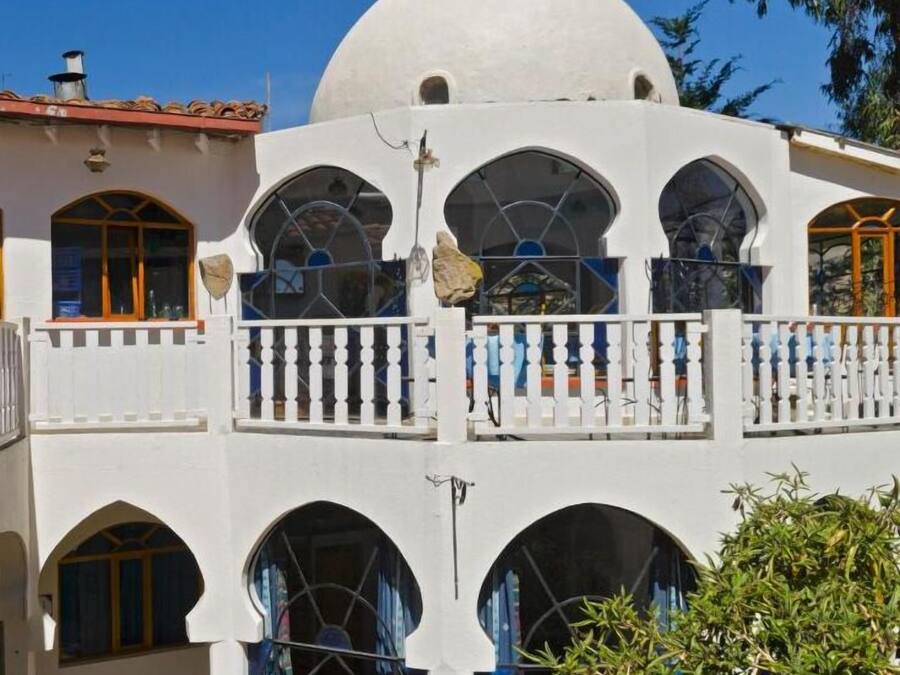 A two-story building with a large white dome and multiple arched windows.