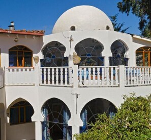 A two-story building with a large white dome and multiple arched windows. - Hotel La Cúpula (Copacabana)