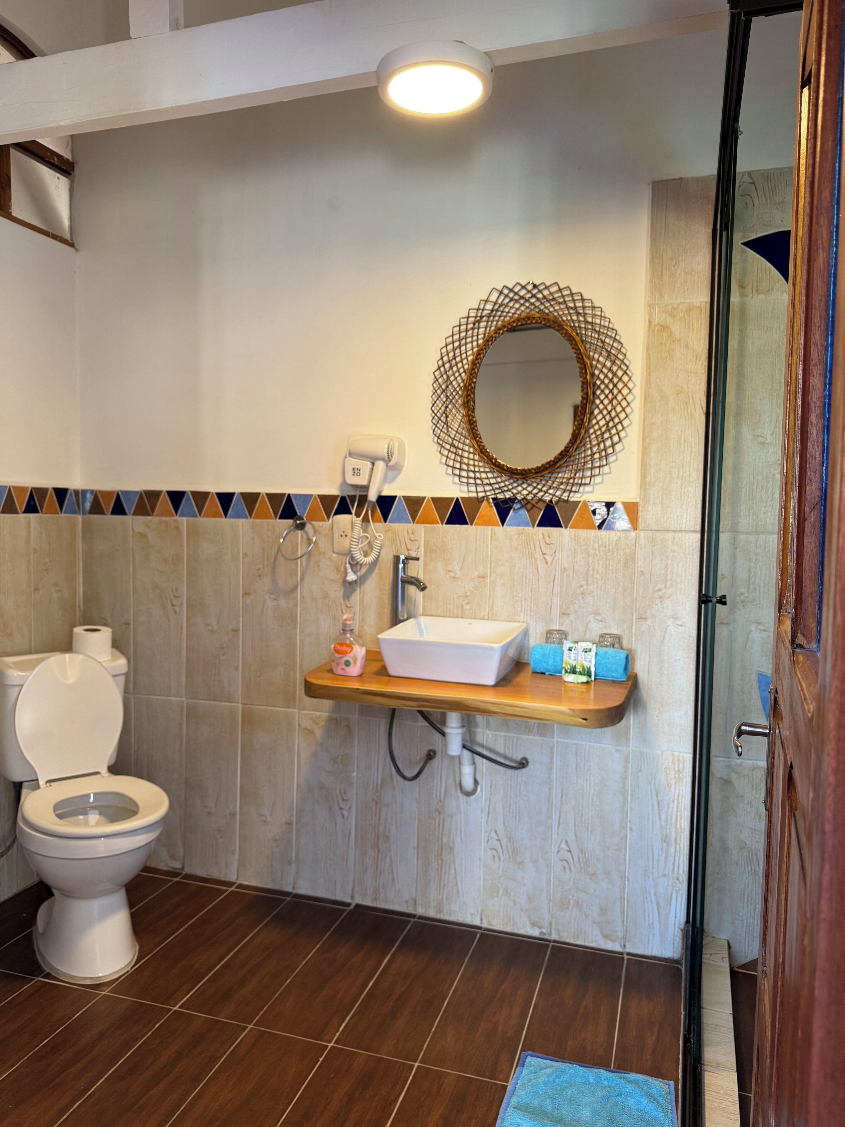 A bathroom with a toilet, sink, and shower area.
