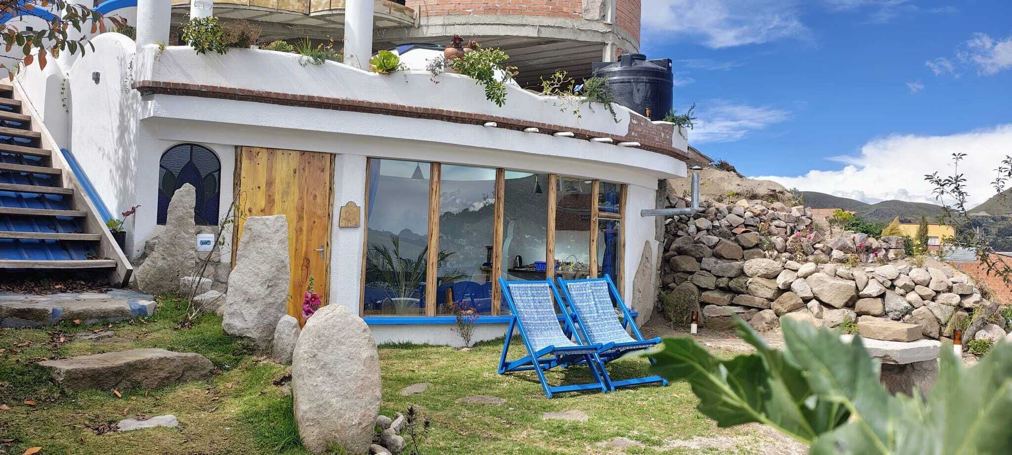 Un edificio moderno con fachada curva, ventanas amplias y un muro de piedra.
