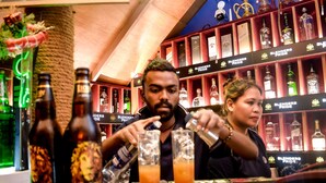 A bar area with shelves of liquor bottles and a bartender preparing drinks. - Sizzlers Hub - Hostel (Kandy)