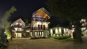 A multi-story hotel with a pub, outdoor seating, and a well-lit entrance. - Sizzlers Hub - Hostel (Kandy)