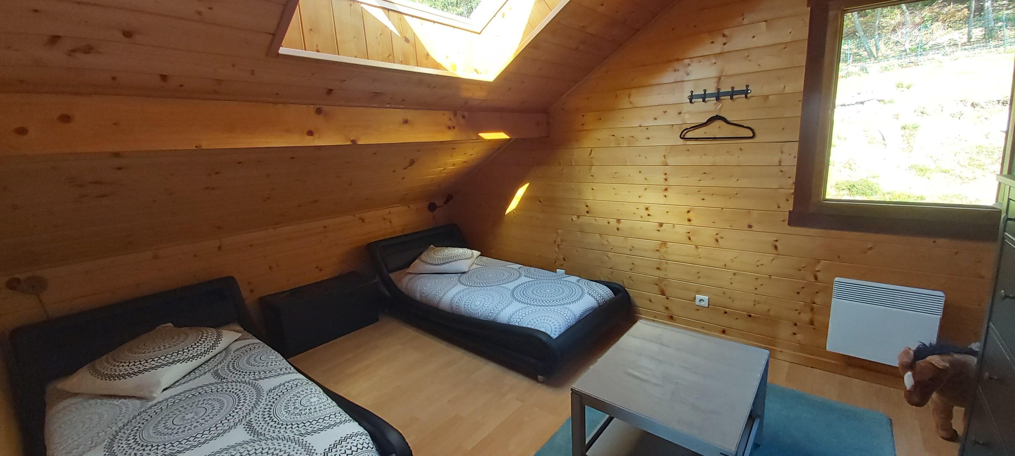 Een gezellig kamer met een slaapzolder, een kleine tafel en een kapstok.