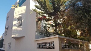 A white building with barred windows and a car parked in front. - Villa of your dreams .. (Agadir)