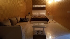 A hotel room with a sofa, a small table, a bed, and a nightstand. - Villa of your dreams .. (Agadir)