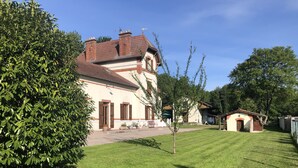 Suuri talo, jossa on hyvin hoidettu nurmikko ja pieni puutarha-alue.