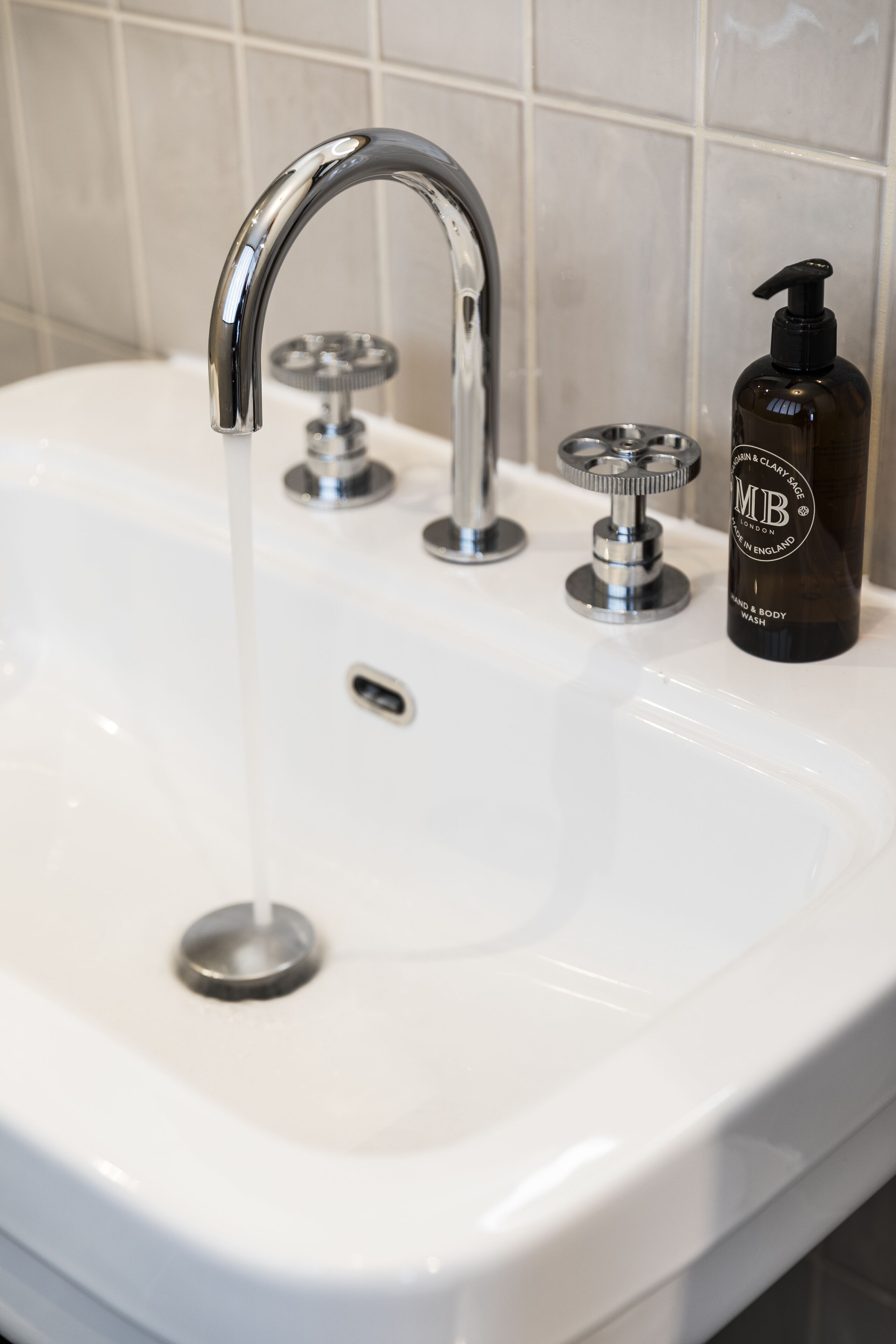 Un lavabo de salle de bain avec un robinet chromé et un distributeur de savon.
