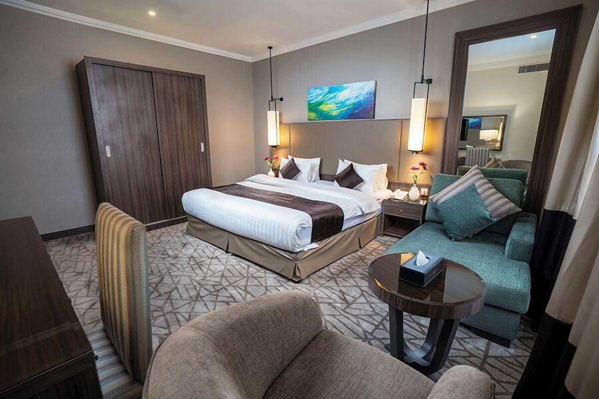 Une chambre d’hôtel avec un grand lit, un canapé, un bureau et une armoire.