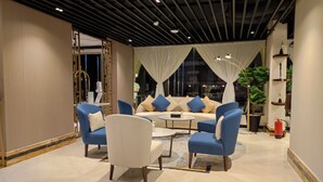 Un espace de détente moderne comprenant un canapé, des fauteuils et une table basse.