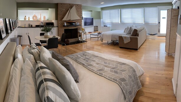 A modern living room with a sofa, a fireplace, and a dining area with a table and chairs.