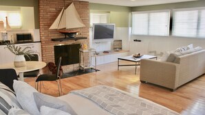 A modern living room with a fireplace, a television, and a sofa.