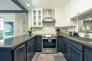 Enjoy cooking in this kitchen with a sink, stainless steel range hood, and large island.