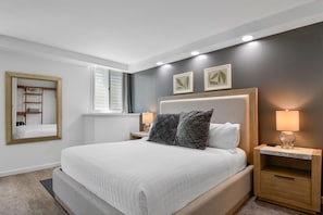 Relax in this serene bedroom with a large bed, nightstand, and wardrobe, perfect for a restful stay.