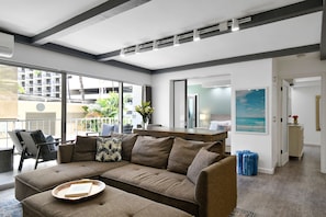 Relax in this stylish living room with a large sofa, dining area, and beautiful views of the surrounding cityscape.